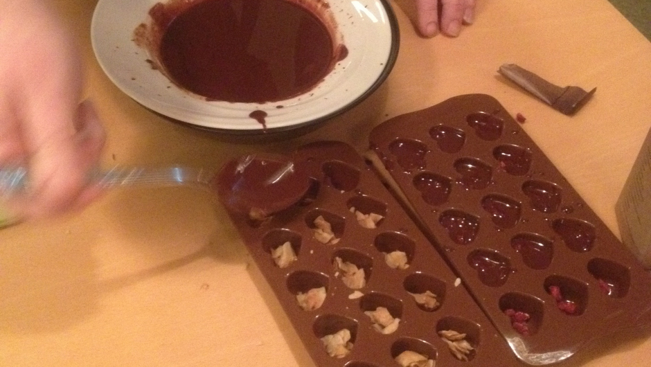 Sjokolade smeltes i vannbad og fylles i silikonformer - gjerne tilsatt fyll