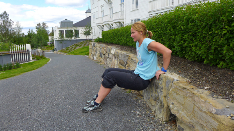 Dips 2 av 2: Bøy i albuen og senk kroppen ned mot bakken. NB! Albuen skal peike bakover. Press opp att. Om det blir for tungt trekk du beina nærmare kroppen. 10-15 gonger x 2. Foto: May-Britt Sægrov. Dips: Bøy i albuen og senk kroppen ned mot bakken. NB! Albuen skal peike bakover. Press opp att. Om det blir for tungt trekk du beina nærmare kroppen. 10-15 gonger x 2. Foto: May-Britt Sægrov.