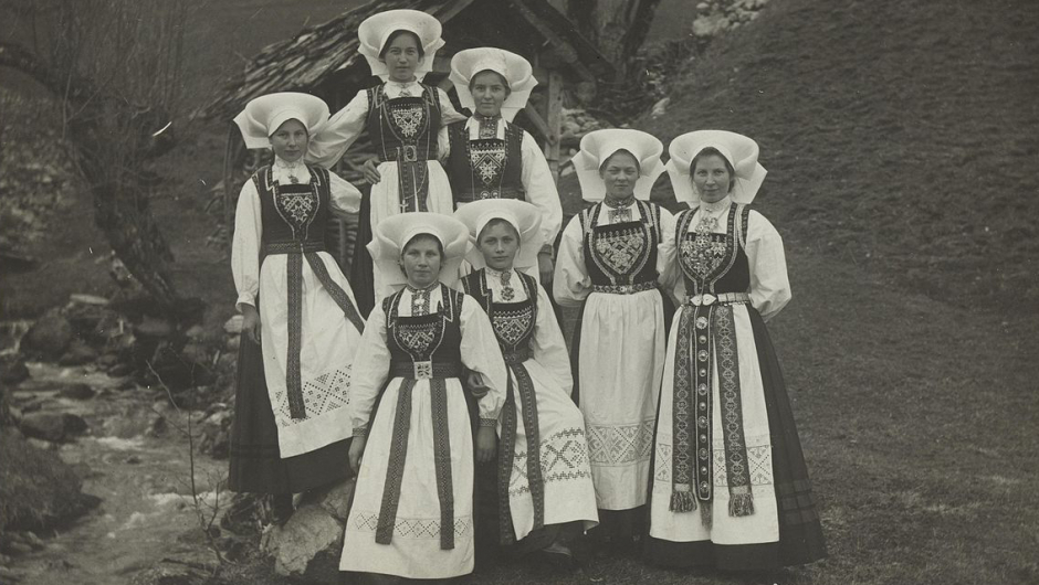 Sju kvinner i hardangerbunad. Foto: Nasjonalbibliotekets bildesamling.