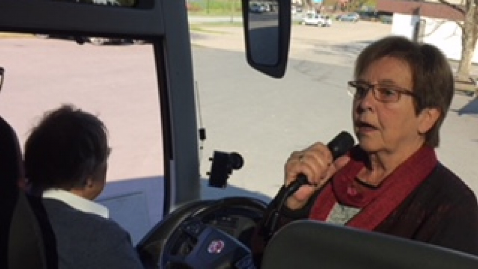 Marit , i Tur-og fest komiteen, orienterer om turen på bussen.