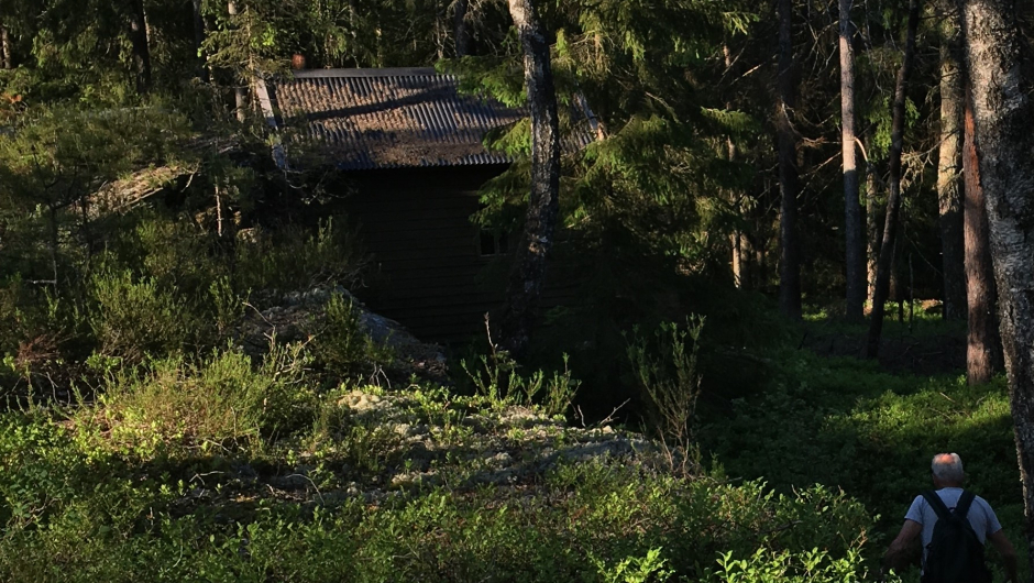 Hytta ligger godt skjult innunder fjellskrenten Hytta ligger godt skjult innunder fjellskrenten