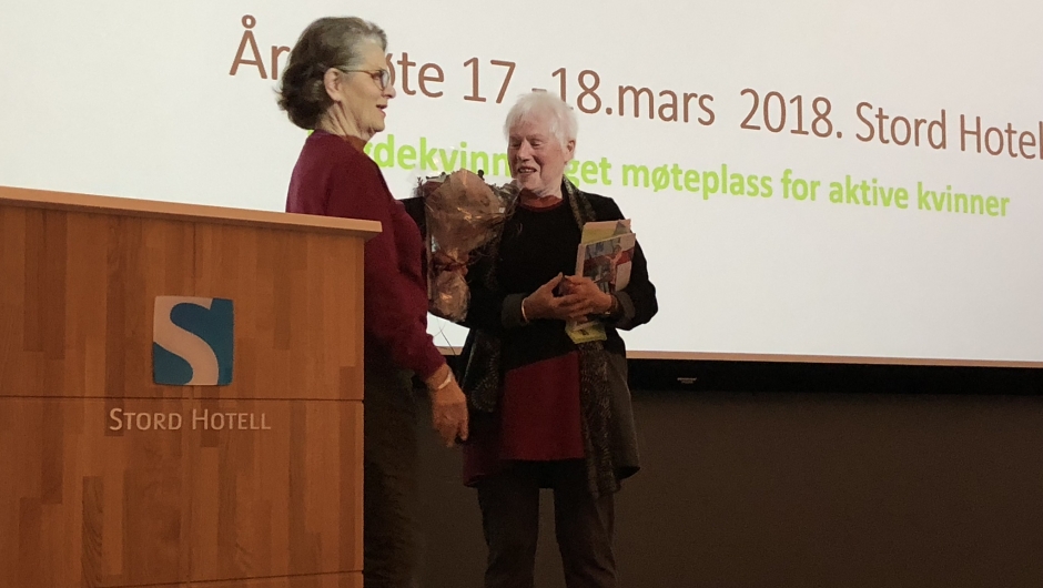 Kjellbjørg Lunde får blomster etter årsmøteforedraget. Kjellbjørg Lunde