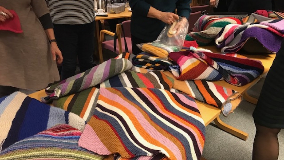 Fargerike, små ulltepper strikket av medlemmer av bygdekvinnelaget og av a