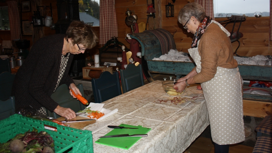 Toril Lyngvær og Vigdis Aarre Olsen skreller grønnsaker til suppa.