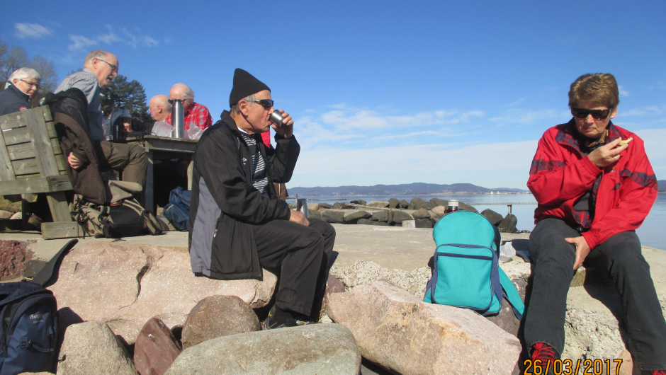 Herlig i solen med kaffekopp.