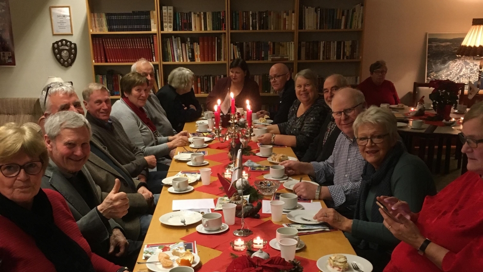 En trivelig samling bygdefolk til bords En trivelig samling bygdefolk til bords