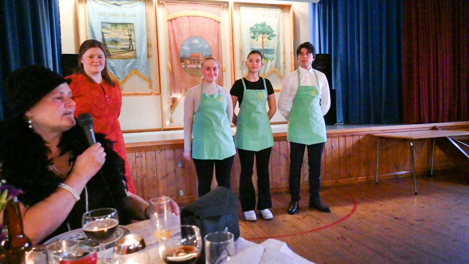 Kveldens servitører stilte i håndbroderte forklær fra den gang laget het 'bondekvinnelag' og ikke 'bygdekvinnelag'. Foto: Boel Kristin Støvern Servitører i håndbroderte forklær fra 'bondekvinnelag'